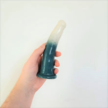 Load image into Gallery viewer, A hand holds a 6 inch curved ceramic dildo in a white and dark green gradient pattern in front of a white background