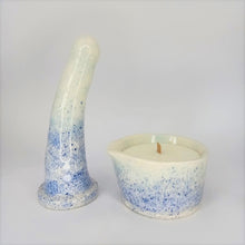 Load image into Gallery viewer, A 6 inch curved ceramic dildo and a matching massage candle in a dark blue to light blue speckle pattern stand in a white photo booth.
