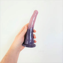 Load image into Gallery viewer, A hand holds a 7 inch curved ceramic dildo in a dark purple to light purple gradient pattern in front of a white background.
